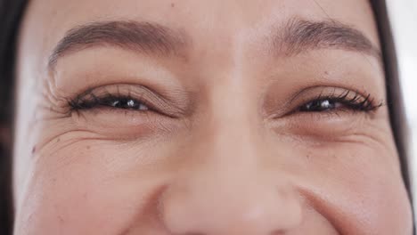 Portrait-close-up-of-brown-eyes-of-happy-biracial-woman-smiling,-in-slow-motion