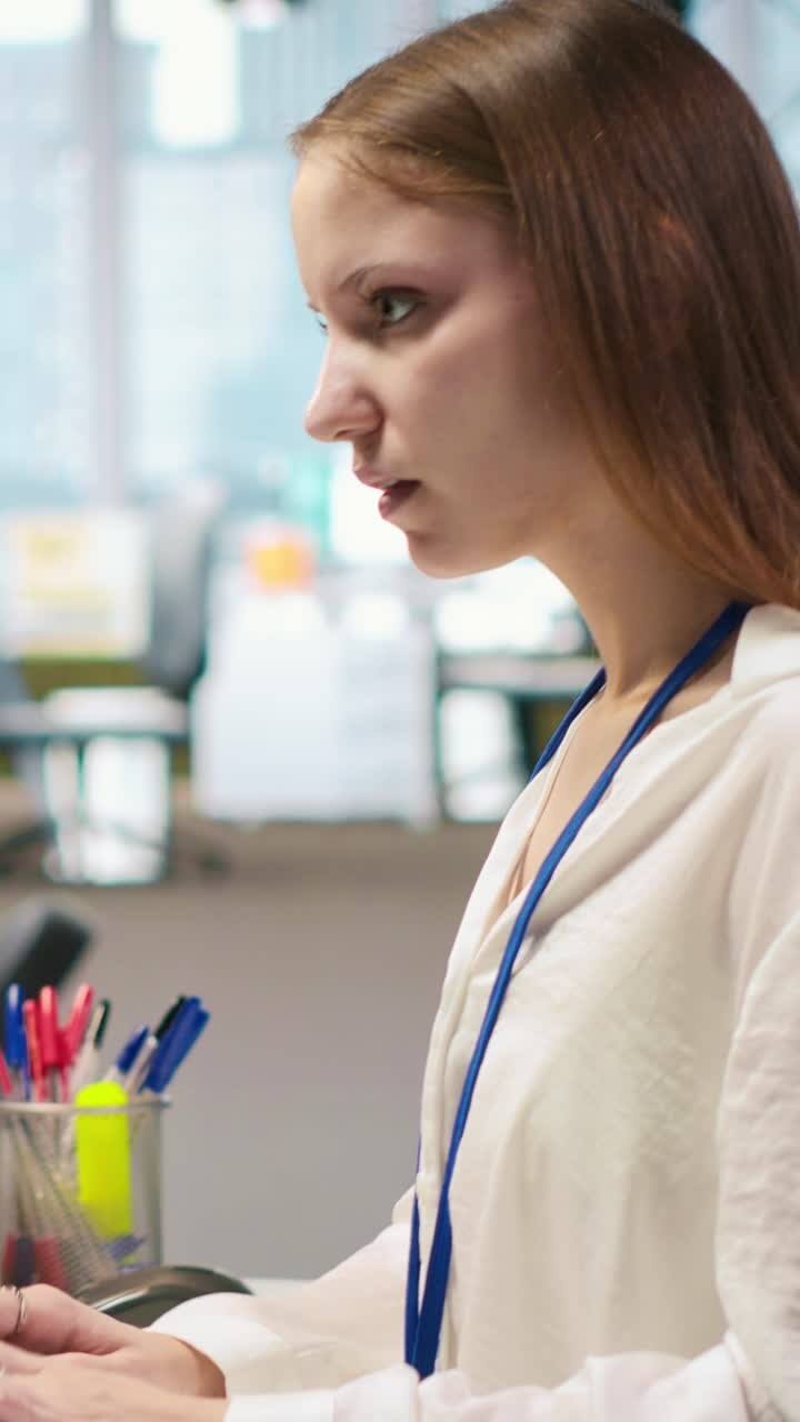Vertical video Female programmer in startup office struggling to fix application errors