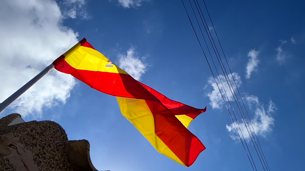 bandera nacional española ondeando en el poste en un día soleado