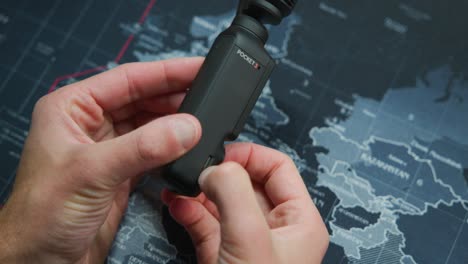 hände, die eine micro-sd-karte aus dem schlitz der dji osmo pocket 3-kamera auswerfen