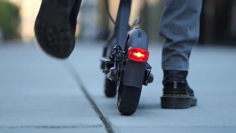 disparo de cerca de la luz de fondo de un scooter eléctrico mientras alguien sube y se va