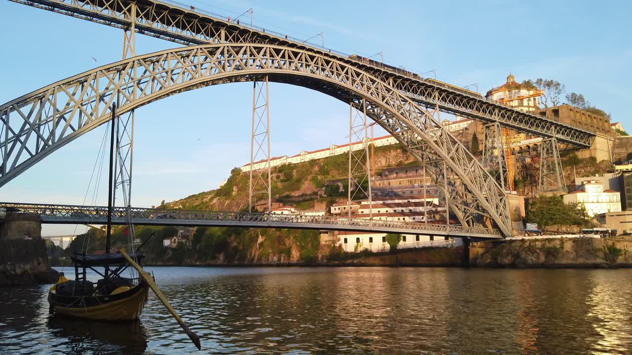 트램이 포르투갈 포르토 루이스 다리를 지나갈 때 보트가 도우로 강에 떠 있습니다.