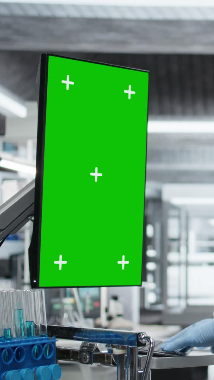 Vertical Video Vertical green screen monitor next to black medic in hazmat suit