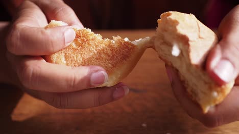 person holding and eating a piece of bread