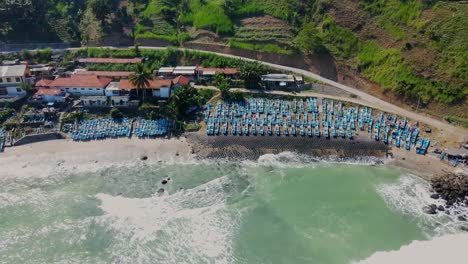 Luftaufnahme-Von-Oben-Nach-Unten-Von-Wellen,-Die-Den-Menganti-Strand-Mit-Parkenden-Fischerbooten-In-Indonesien-Erreichen