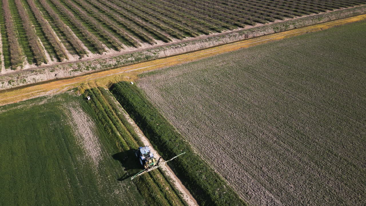 Local Spain farmer cleaning irrigation ditch, aerial view