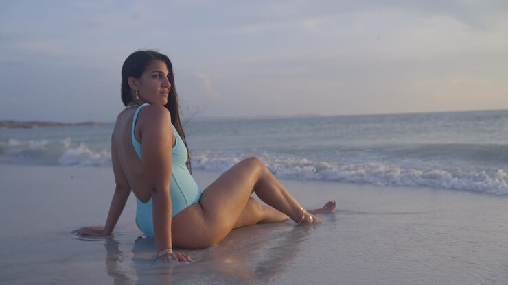 Venezuelan brunette latina in swimsuit enjoying the sun on Coche Island, Margarita at sunset