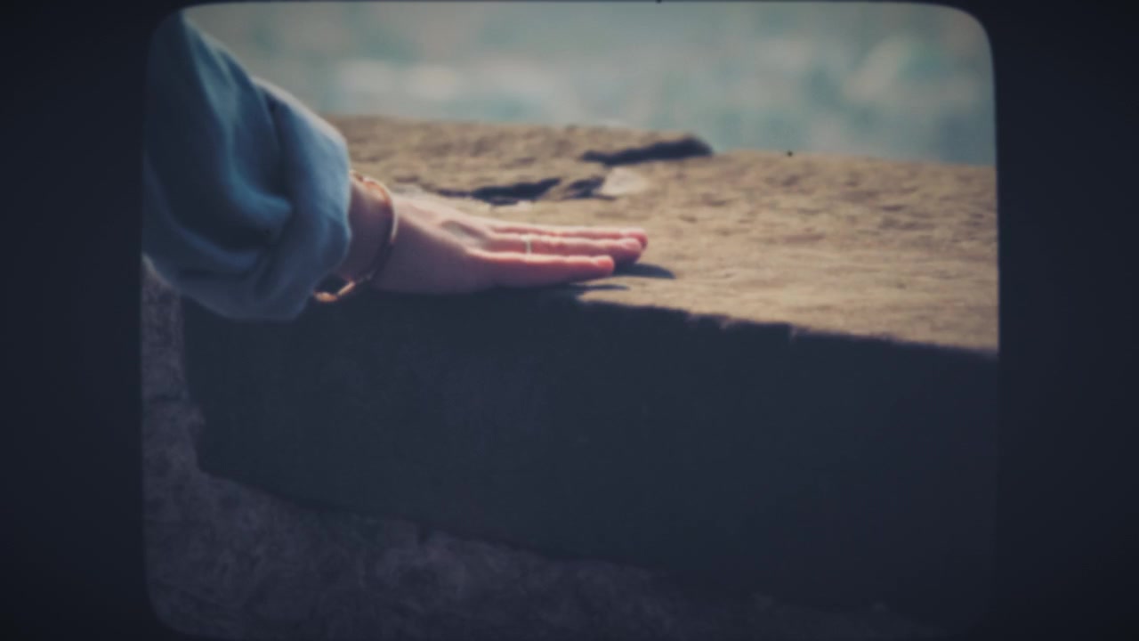 Mão de mulher tocando pedra durante caminhada