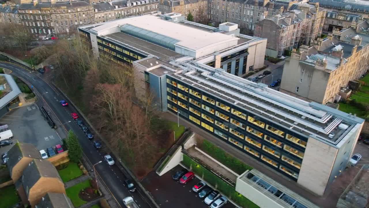 View of a modern office building in Edinburgh, surrounded by historic residential structures and narrow streets. Captures urban planning and contemporary and traditional architecture.