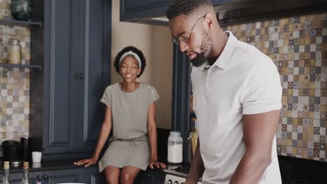 happy african american couple talking and cooking together in ktichen in slow motion