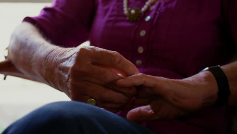 Mid-section-of-senior-woman-sitting-with-folded-hands-on-her-lap-at-home-4k