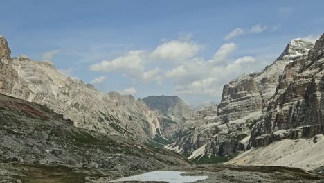 panoramic view of rocky valley in italian dolomites with some remaining snow