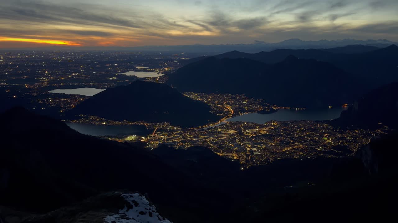 con vistas al paisaje urbano iluminado de lecco desde la montaña durante el anochecer