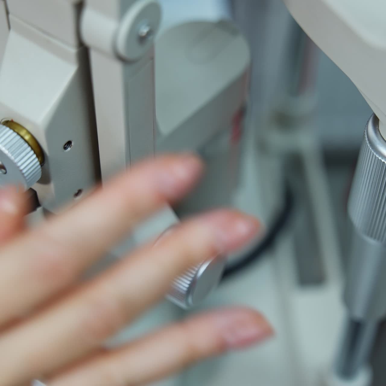 Apparatus for checking eyesight. Female's hand of a doctor customizing ophthalmological device. Close-up