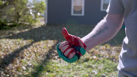 tracking out injured hand with improvised tourniquet, man move his bloody fingers