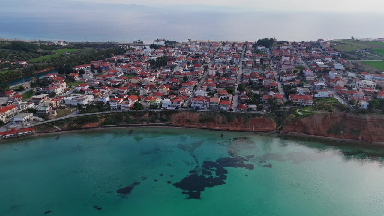 vista aérea de potidaia, una ciudad costera en grecia, con aguas verdes cristalinas del egeo.