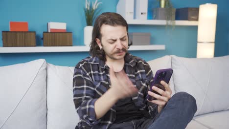 the young man who is surprised and angry at what he sees on the phone.