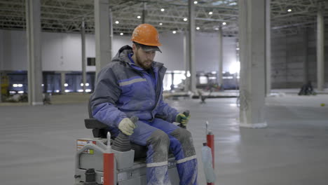 trabajador de la construcción que opera una máquina de pulido de pisos