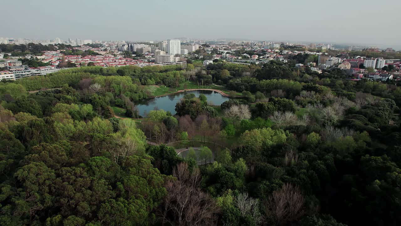 Expansive aerial view of Porto City Park - Parque da Cidade in Portugal featuring a central lake and walking paths and vast urban oasis contrasted with distant city skyline