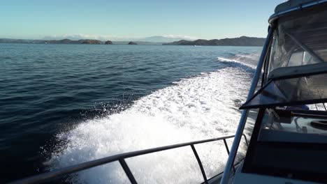 static shot of side of a small boat sailing through the sea leaving a wake