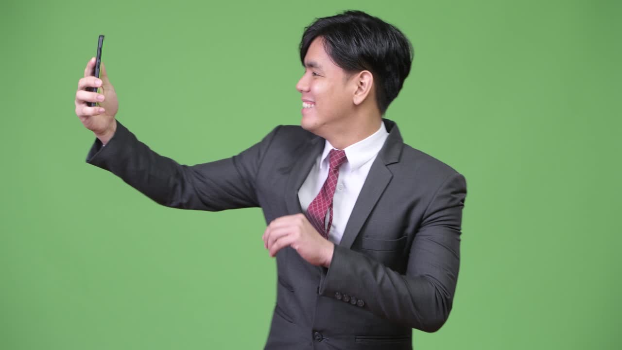 휴대전화를 사용하는 젊은 잘생긴 아시아 사업가