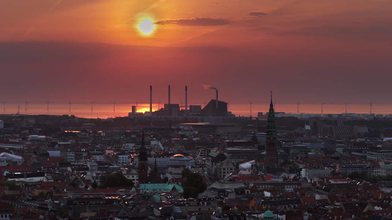 Aerial drone view of the skyline of Copenhagen, Denmark with Amager Bakke and offshore wind turbines at sunrise