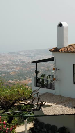 traditional whitewashed andalusian house with terracotta roof tiles and balcony overlooks coastal city