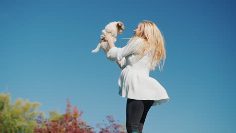mujer sosteniendo cachorro saltando