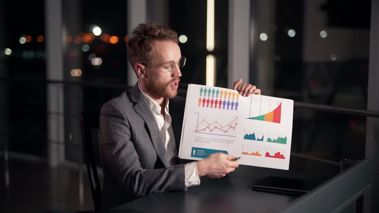 Stylish young man gives a presentation on a slide infographic looking at the camera