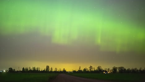 Helle-Nordlichter-über-Einem-Ländlichen-Dorf-Und-Einem-Wald-In-Silhouette---Zeitraffer