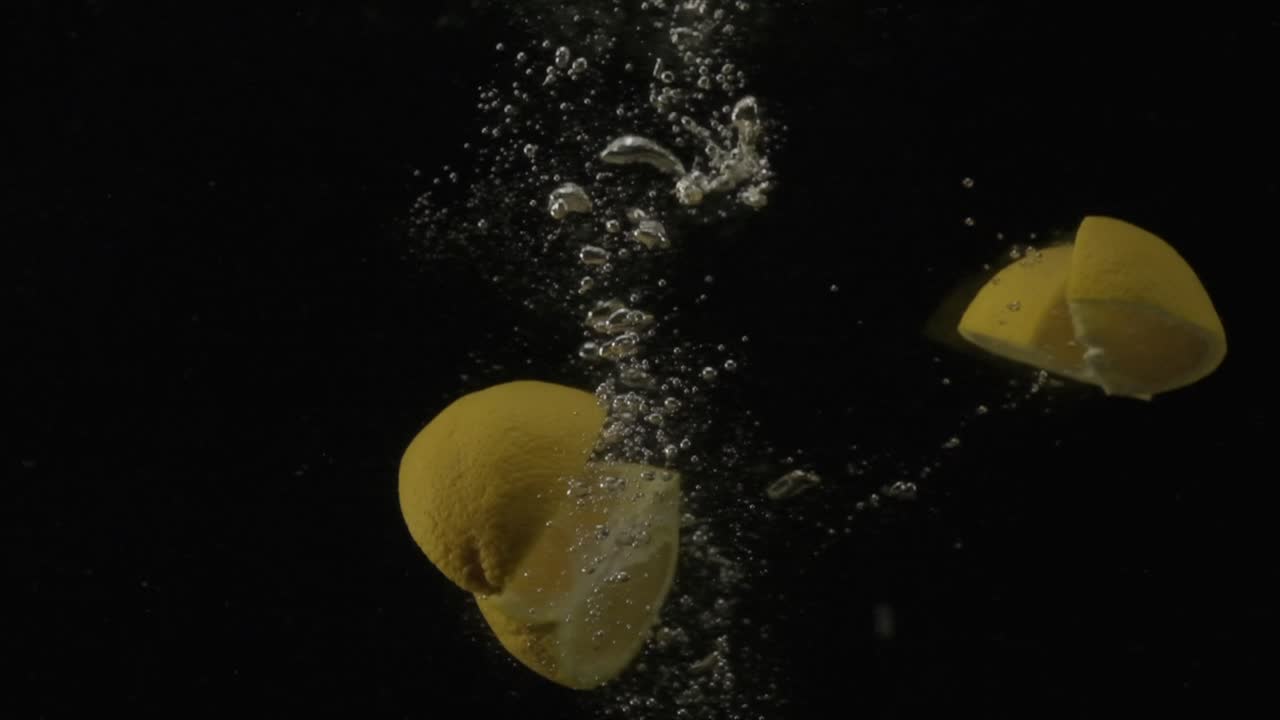 una naranja que se deja caer en un tanque de agua y se divide en cuatro pedazos