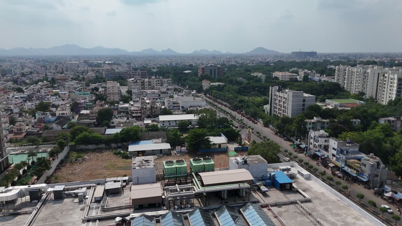 Un'ampia veduta aerea della città di Vijayawada, che mostra l'integrazione delle strutture urbane con la collina naturale sullo sfondo.