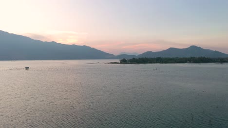 Dreamy-aerial-drone-of-picturesque-and-peaceful-asian-landscape-with-lake,-mountains-and-local-fishing-village-in-Lang-Co,-Vietnam