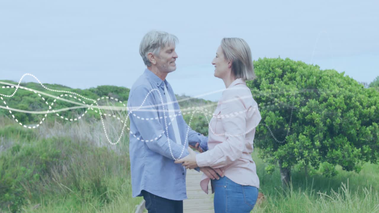 Couple facing other initiating embrace on boardwalk animated waveform highlighting lifestyle tie