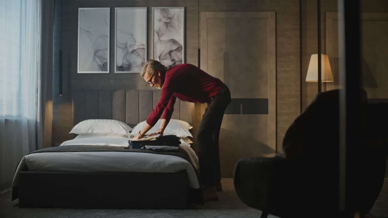 Man Packing Suitcase in Hotel Room