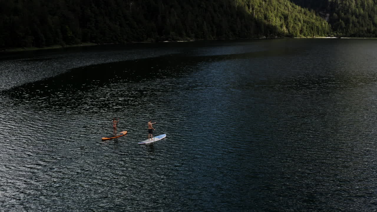 Couple Paddleboarding on a Serene Mountain Lake