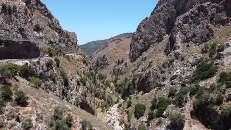 cars driving on scenic mountain pass on edge of topoliana gorge, crete