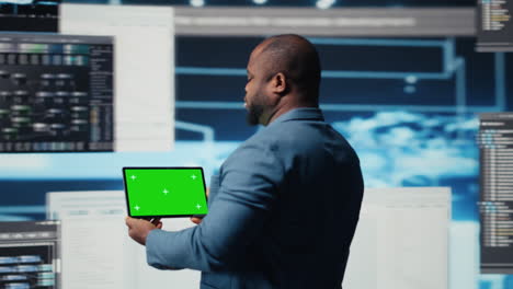 african american it specialist shows tablet with chroma key screen
