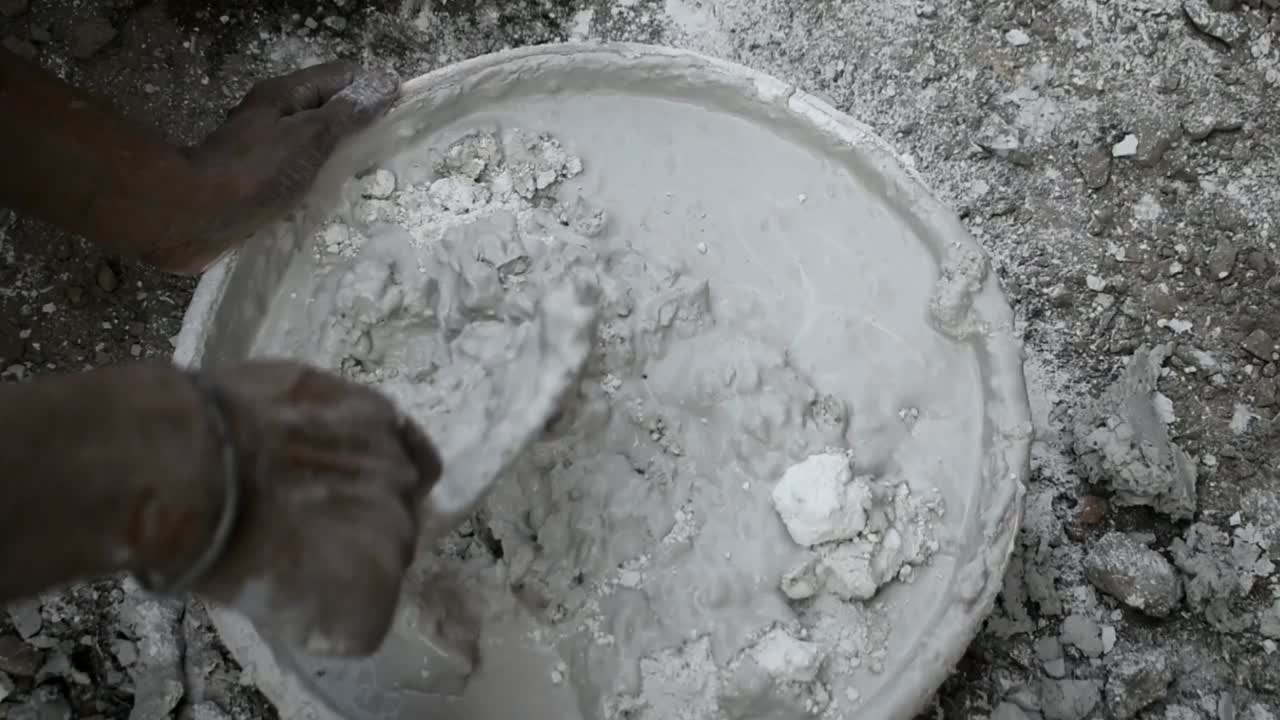 흙손 공사로 더러운 콘크리트 시멘트를 수동으로 혼합