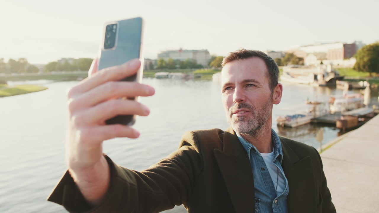Homem tirando uma selfie perto do rio na cidade