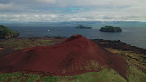 cráter volcánico eldfell por el archipiélago de westman, sur de islandia con ferry de vela en el fondo