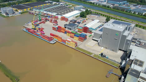 volando hacia un pequeño astillero con un barco de carga atracado cargado de contenedores