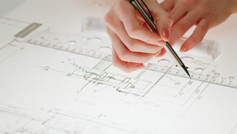 close-up of hands working on architectural blueprints