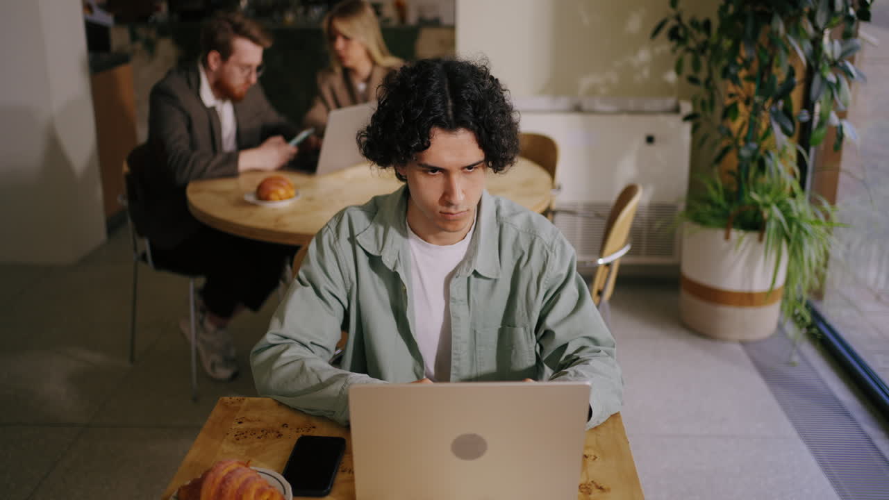 A man working on a laptop in a cafe