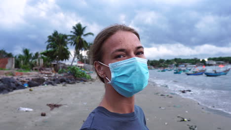 close up static shot of girl putting on face mask and taking off, showing to camera