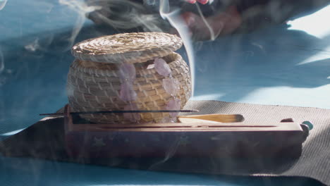 smoke from burning incense stick in holder on floor in room