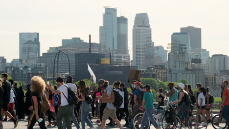 peaceful black lives matter protesters march in front of minneapolis skyline