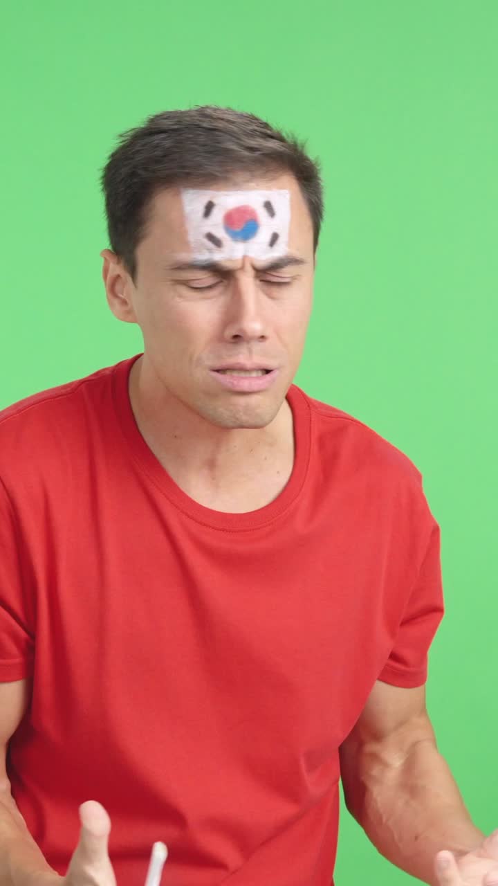 Nervous man cheering for South Korea during a match looking away