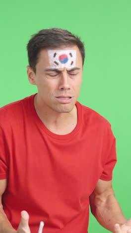 nervous man cheering for south korea during a match looking away