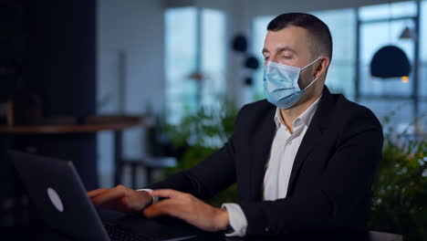 businessman working from home during pandemic wearing mask